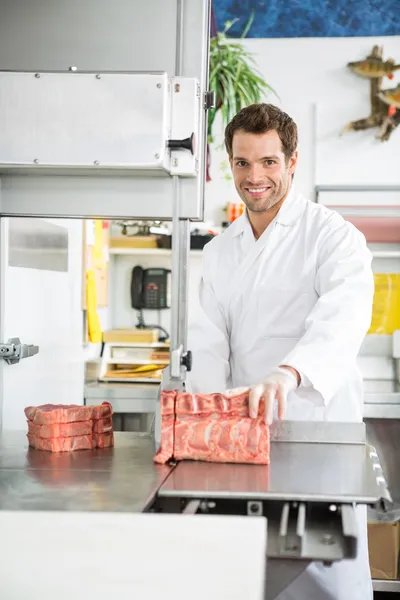 Portrait of Butcher Slicing Meat on Bandsaw — стоковое фото