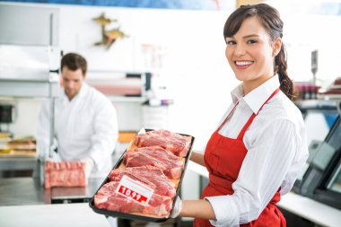 Happy Butcher Holding Meat Tray In Store clipart