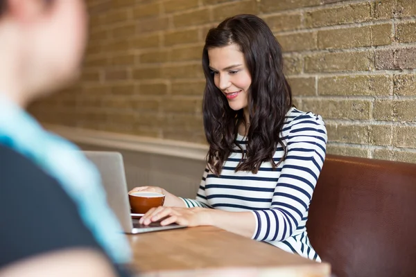 Schöne Frau mit Laptop in Cafeteria — Stockfoto