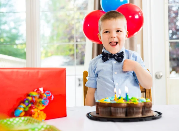 Geburtstagskind mit Kuchen und Geschenk auf dem Tisch — Stockfoto