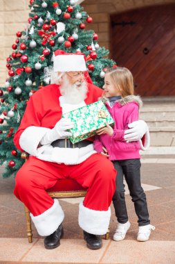 Santa Claus Giving Gift To Girl