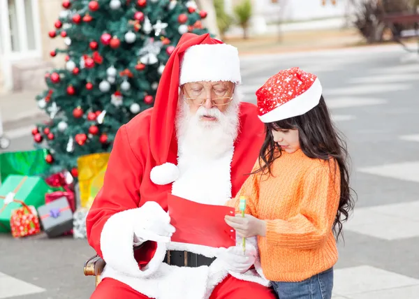 Menina mostrando lista de desejos para Papai Noel — Fotografia de Stock