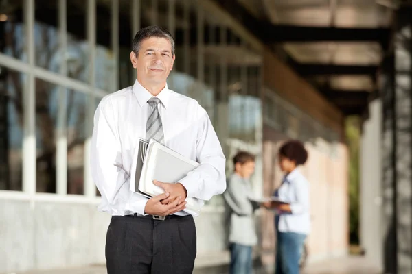 Teacher Holding Books While Standing On Campus — Stock Photo, Image