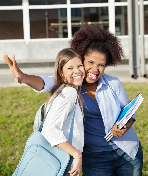 Estudantes do sexo feminino fazendo expressões faciais no campus — Fotografia de Stock