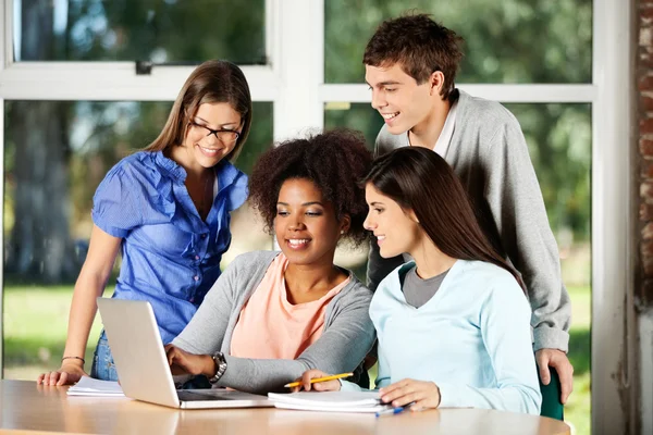 Studenti universitari che utilizzano il computer portatile alla scrivania in aula — Foto Stock