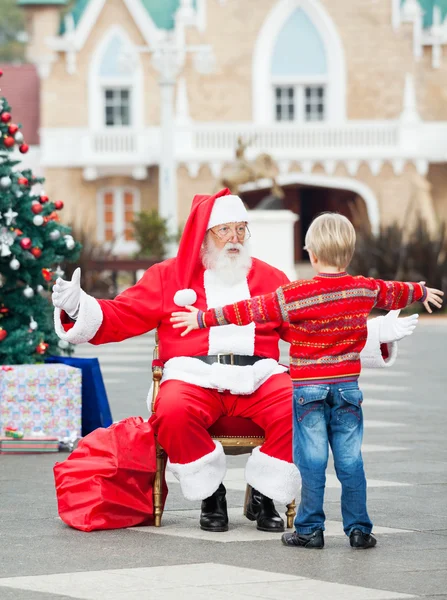 Menino prestes a abraçar Papai Noel — Fotografia de Stock