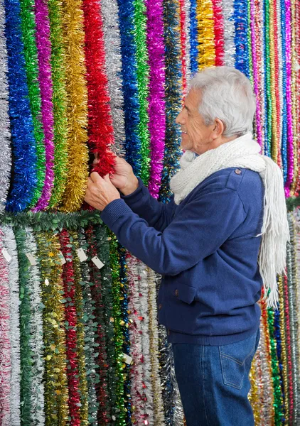 Senior man winkelen voor tinsels — Stockfoto