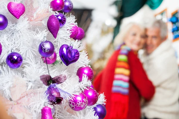 Árbol de Navidad decorado y pareja en la tienda — Foto de Stock