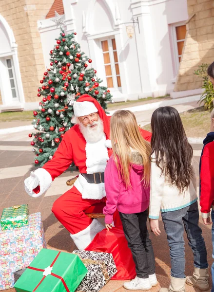 Santa Claus Gesturing While Looking At Girl Stock Photo