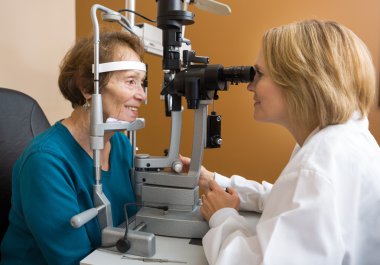 Eye Doctor Examining Woman's Vision clipart