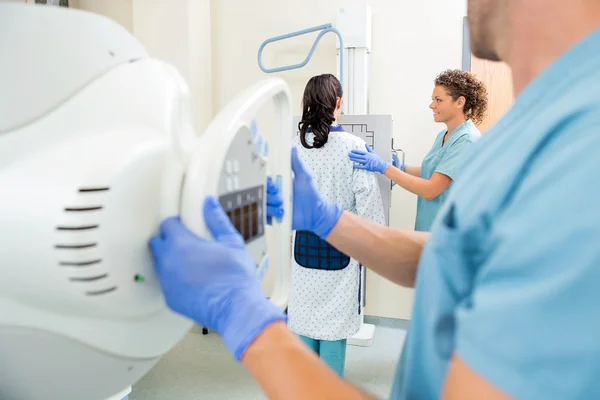 Enfermeira ajustando a máquina de raios X na sala de exame — Fotografia de Stock
