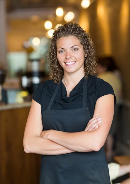 Cameriera in piedi braccia attraversato in espresso bar — Foto Stock