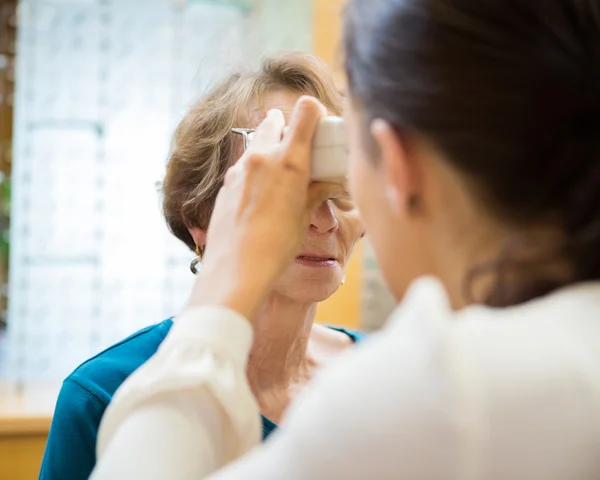 Optometrista Examinando a Visão da Mulher Sênior — Fotografia de Stock