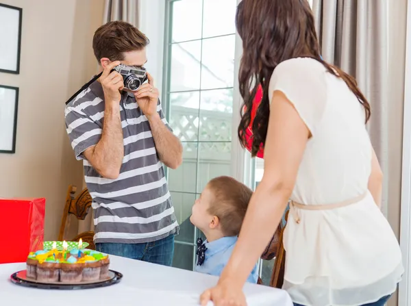 Человек фотографирует семью на дне рождения — стоковое фото