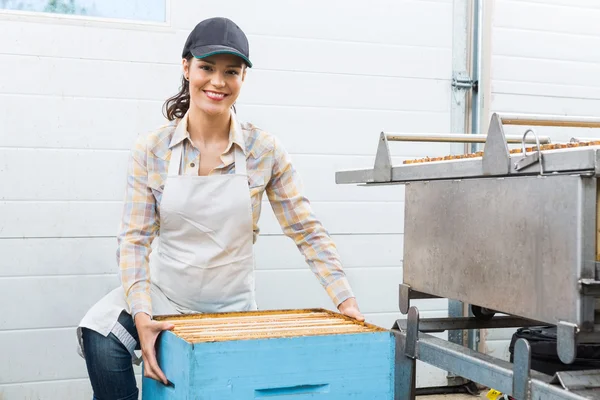 Apicultor feminino com caixa de favo de mel na fábrica — Fotografia de Stock