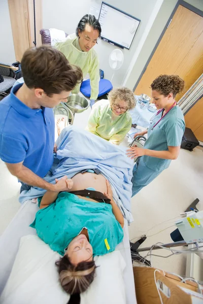 Homem segurando a mão da mulher durante o parto no hospital — Fotografia de Stock