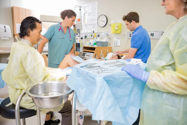 Médico operando mujer embarazada durante el parto con el hombre y Nur — Foto de Stock