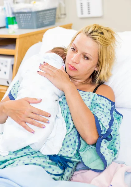 Vrouw met baby rusten op haar schouder in het ziekenhuis — Stockfoto