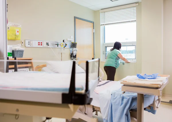 Беременная женщина у окна в больничной палате — стоковое фото