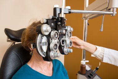 Woman Undergoing Eye Examination With Phoropter clipart
