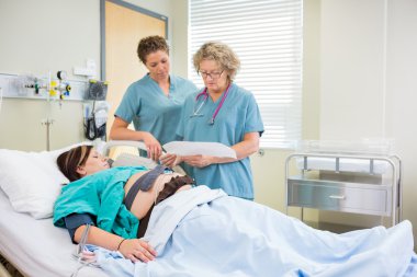 Fetal monitörü raporu inceleyerek hemşireler