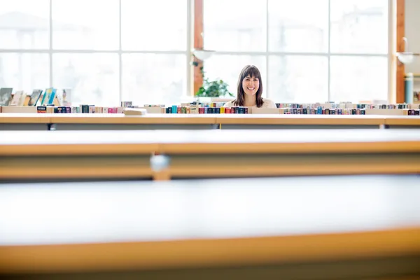 Studentin lächelt in Buchhandlung — Stockfoto