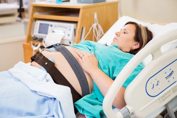 Geboorte vrouw met elektronische fetal monitor aangesloten — Stockfoto