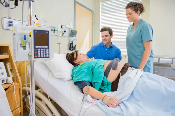 Happy Man And Nurse Looking At Pregnant Woman — Stock Photo, Image