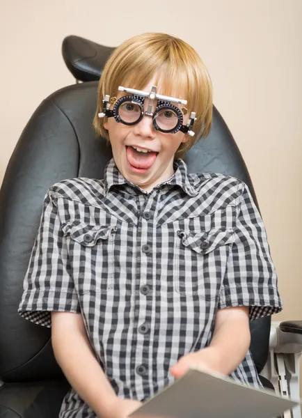 Jongen met proef frame maken van grappige gezicht op opticien — Stockfoto