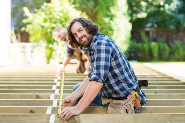 Porträt eines Tischlers, der Holz mit Klebeband misst — Stockfoto