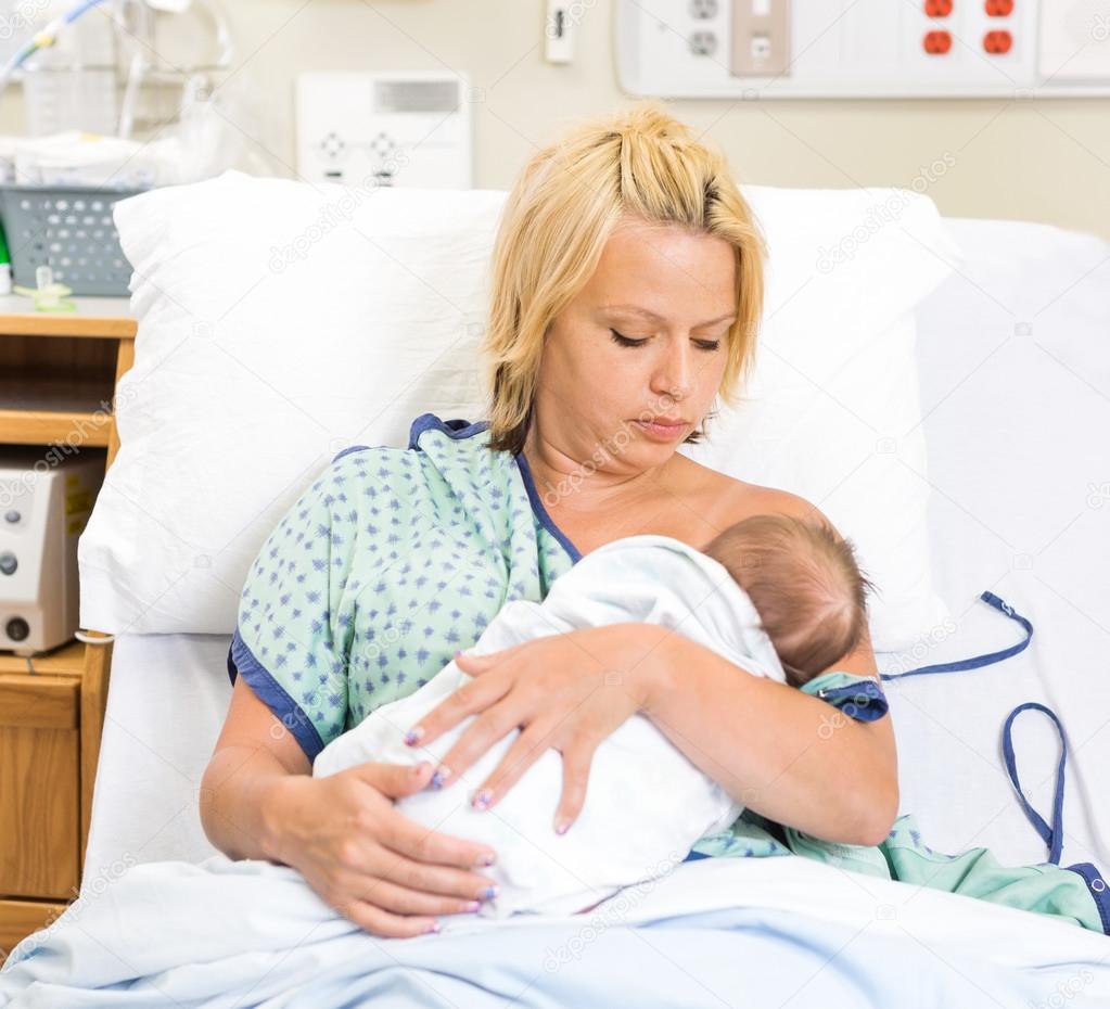 Woman Breast Feeding Newborn Babygirl In Hospital