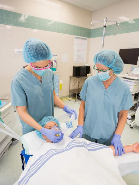 Enfermeras ajustando máscara de oxígeno en paciente femenino — Foto de Stock
