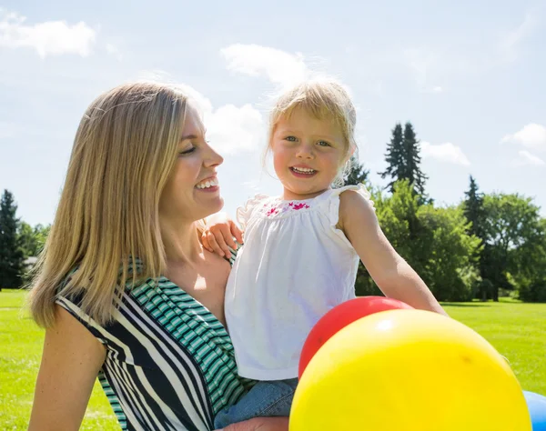 Moeder en dochter met ballonnen in park — Stockfoto