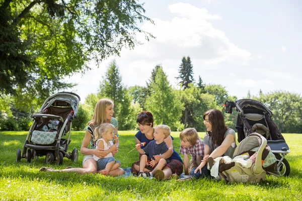 Moeders en kinderen genieten van picknick in het park — Stockfoto