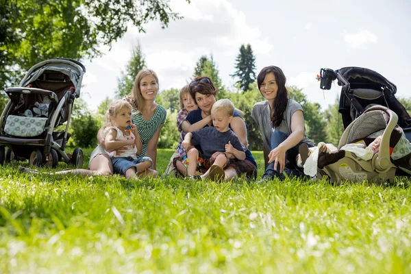 Mujeres con sus hijos disfrutando de un picnic — Foto de Stock