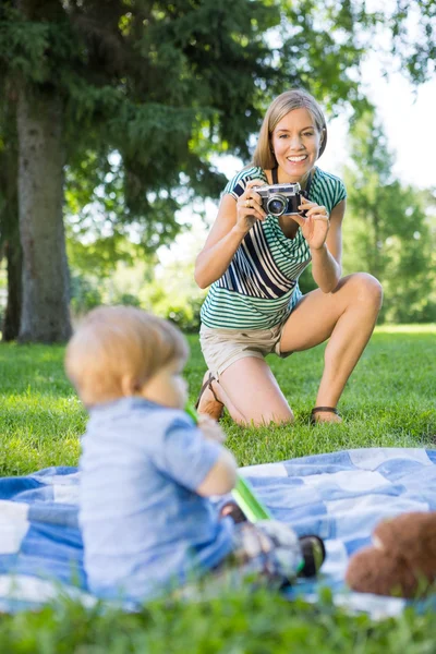 Donna cliccando foto di bambino ragazzo in parco — Foto Stock