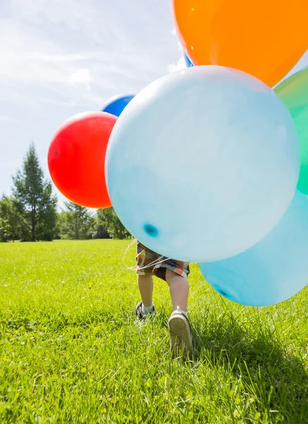 Pojke med färgglada ballonger i park — Stockfoto