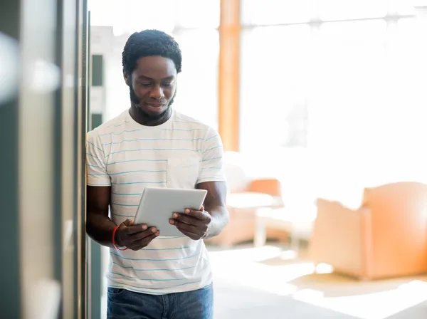 Étudiant utilisant une tablette numérique à la bibliothèque — Photo