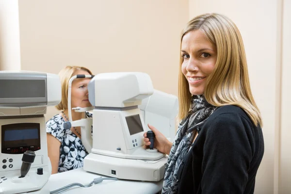 Optometrista usando o Tonometer para medir a pressão ocular dos pacientes — Fotografia de Stock