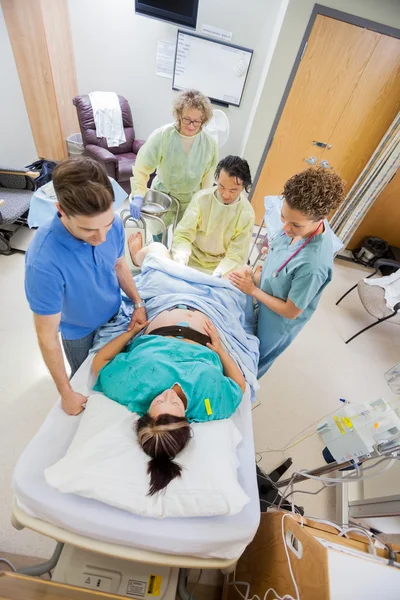 Médecins avec infirmière opérant femme enceinte pendant l'accouchement — Photo