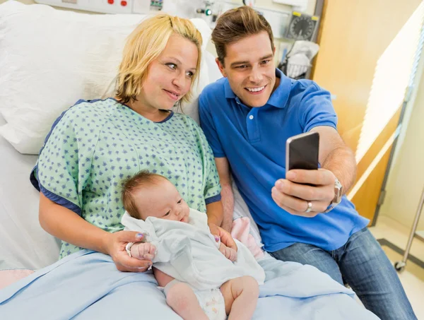 Man met vrouw en babygirl nemen zelfportret door mobiele p — Stockfoto