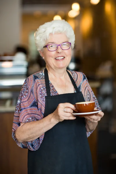 Щасливі офіціантка з чашкою кави в кафетерії — стокове фото