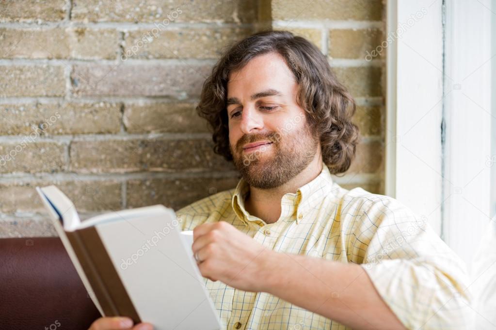 Man Reading Book In Coffeeshop
