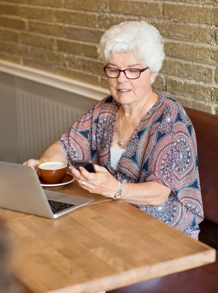 Nő SMS segítségével okostelefon kávézó — Stock Fotó