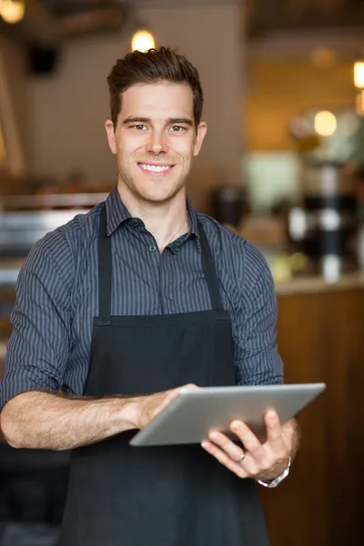 Lycklig ägare innehar digital tablet i café — Stockfoto