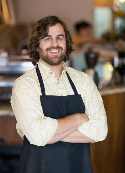 Male Owner Standing Arms Crossed In Cafeteria