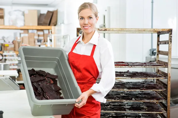 Travailleur montrant boeuf Jerky dans le panier à la boutique — Photo