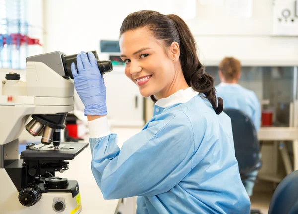 Pesquisador usando microscópio em laboratório — Fotografia de Stock