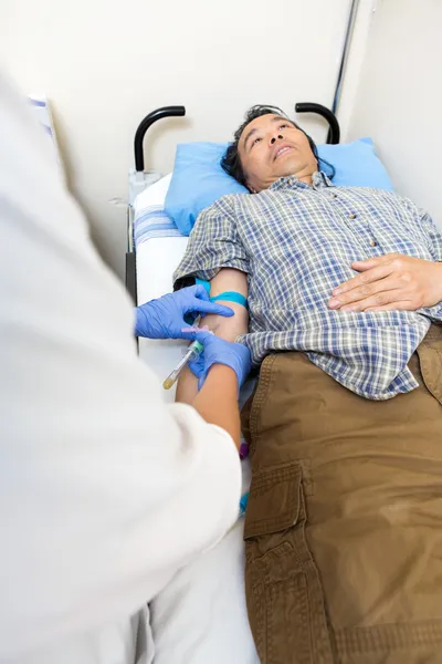 Doutor tirando sangue do braço do paciente — Fotografia de Stock