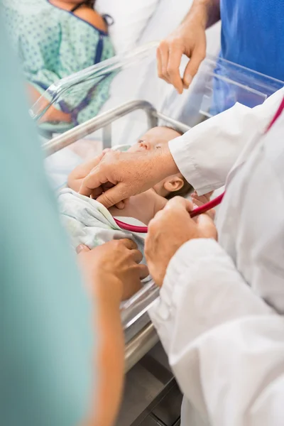 Доктор осматривает новорожденную девочку в больнице — стоковое фото